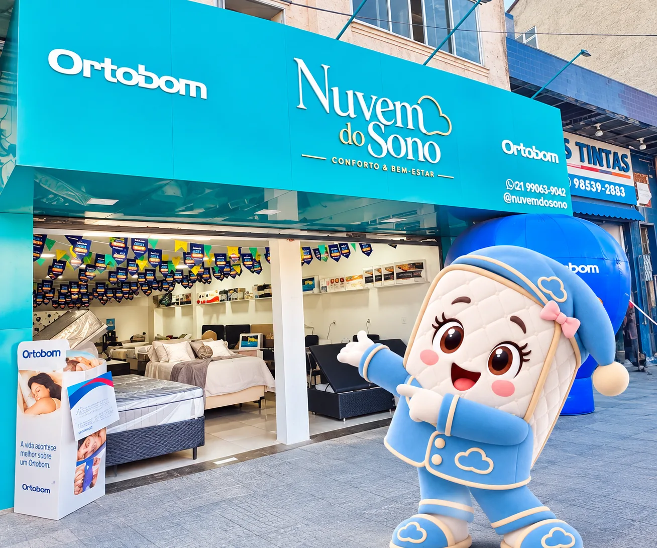 Fachada da loja Nuvem do Sono em Pilares, com o mascote da marca na calçada e os colchões Ortobom montados no salão